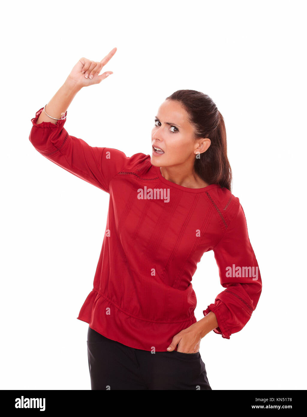 Portrait of surprised lovely woman pointing up and looking at you while standing on isolated white background - copyspace. Stock Photo