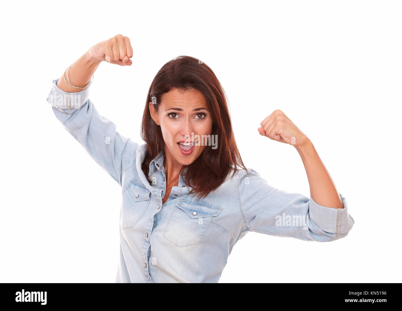 Portrait of positive young lady on blue shirt celebrating her victory with nice face on isolated studio. Stock Photo