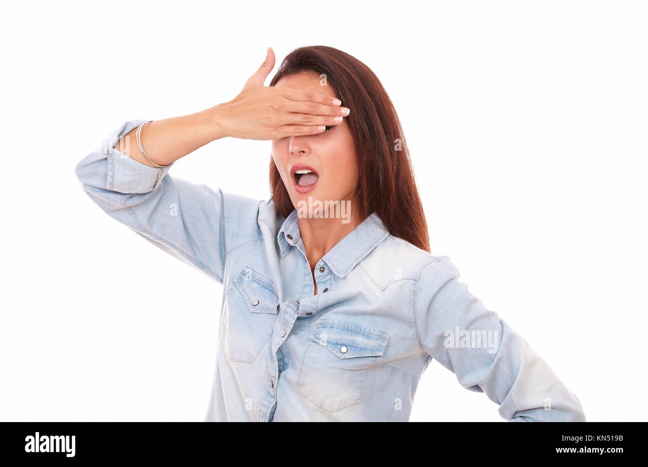 Portrait of excited pretty woman on blue blouse closing her eyes while standing on isolated studio. Stock Photo