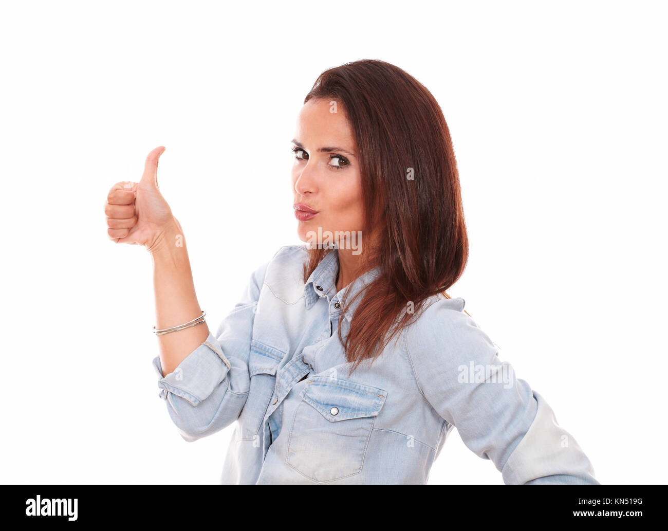 Portrait of sexy hispanic woman on blue blouse with thumb up looking at you on isolated studio. Stock Photo