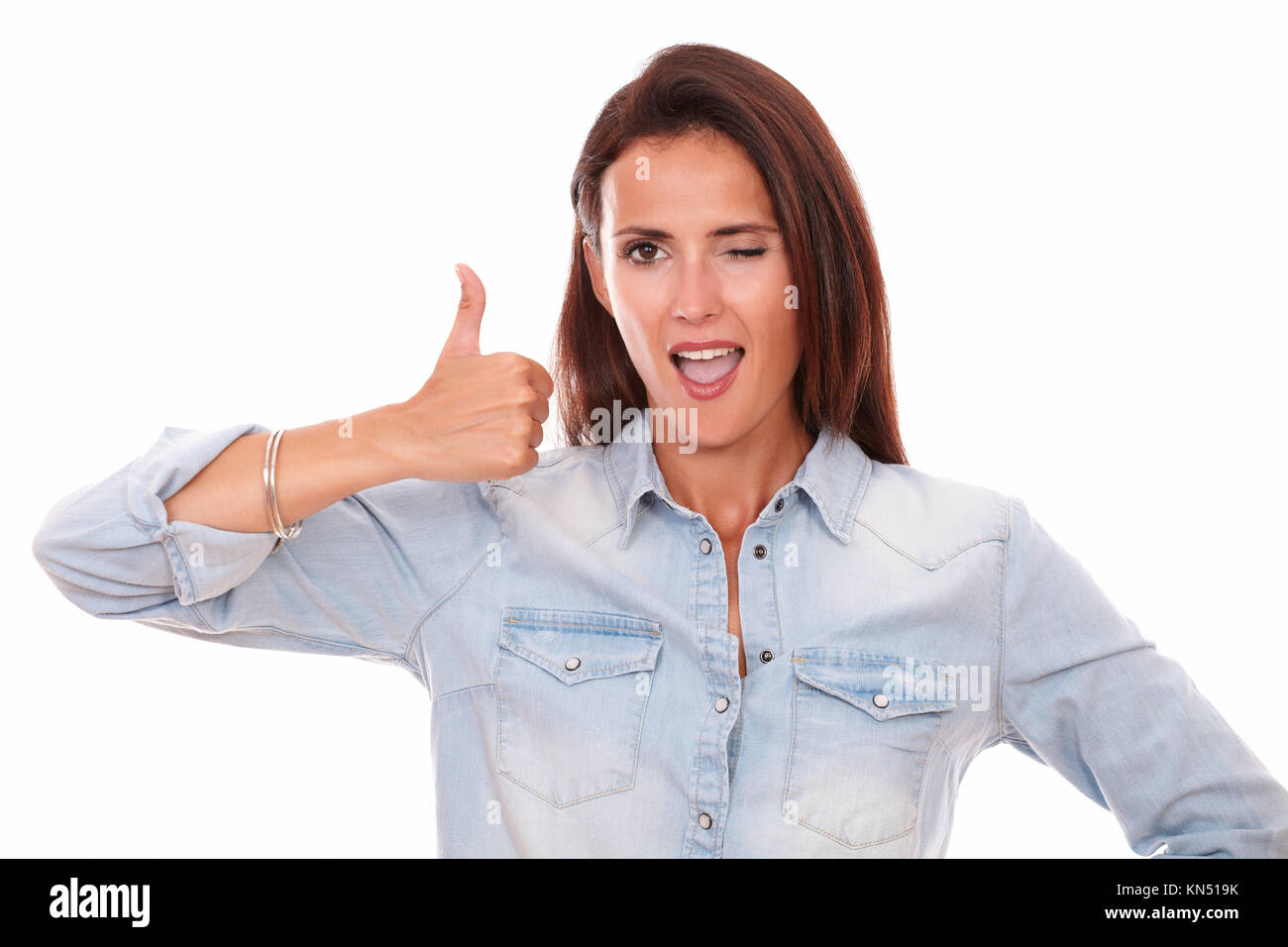 Portrait of satisfied young woman on blue blouse with good job gesture smiling at you on isolated studio. Stock Photo