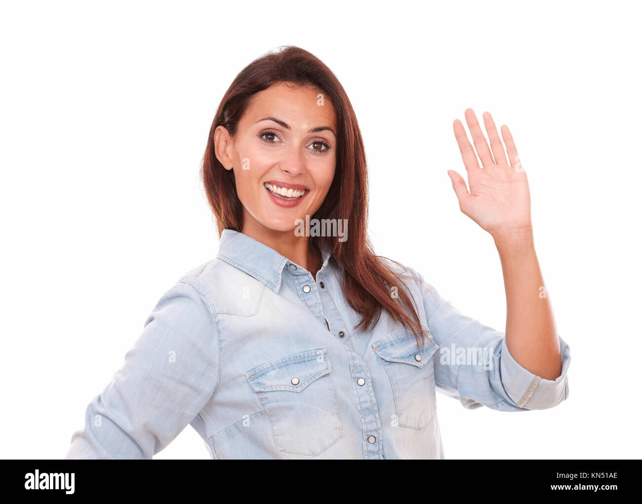 Portrait of adult hispanic female on blue blouse with greeting hand smiling at you on isolated studio. Stock Photo