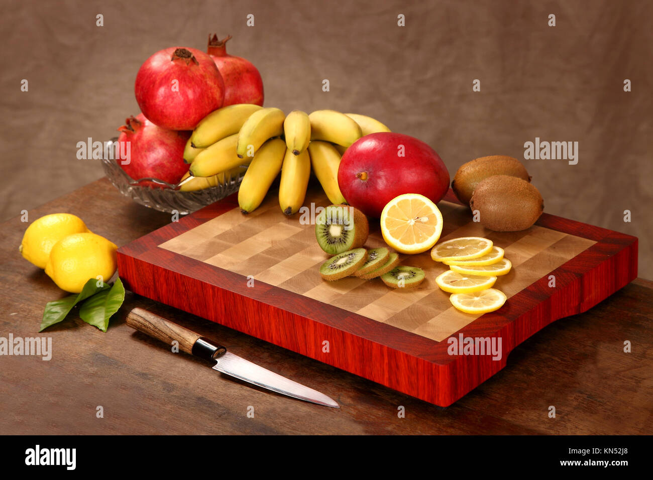tropical fruit cut by segments by means of a knife on a chopping board