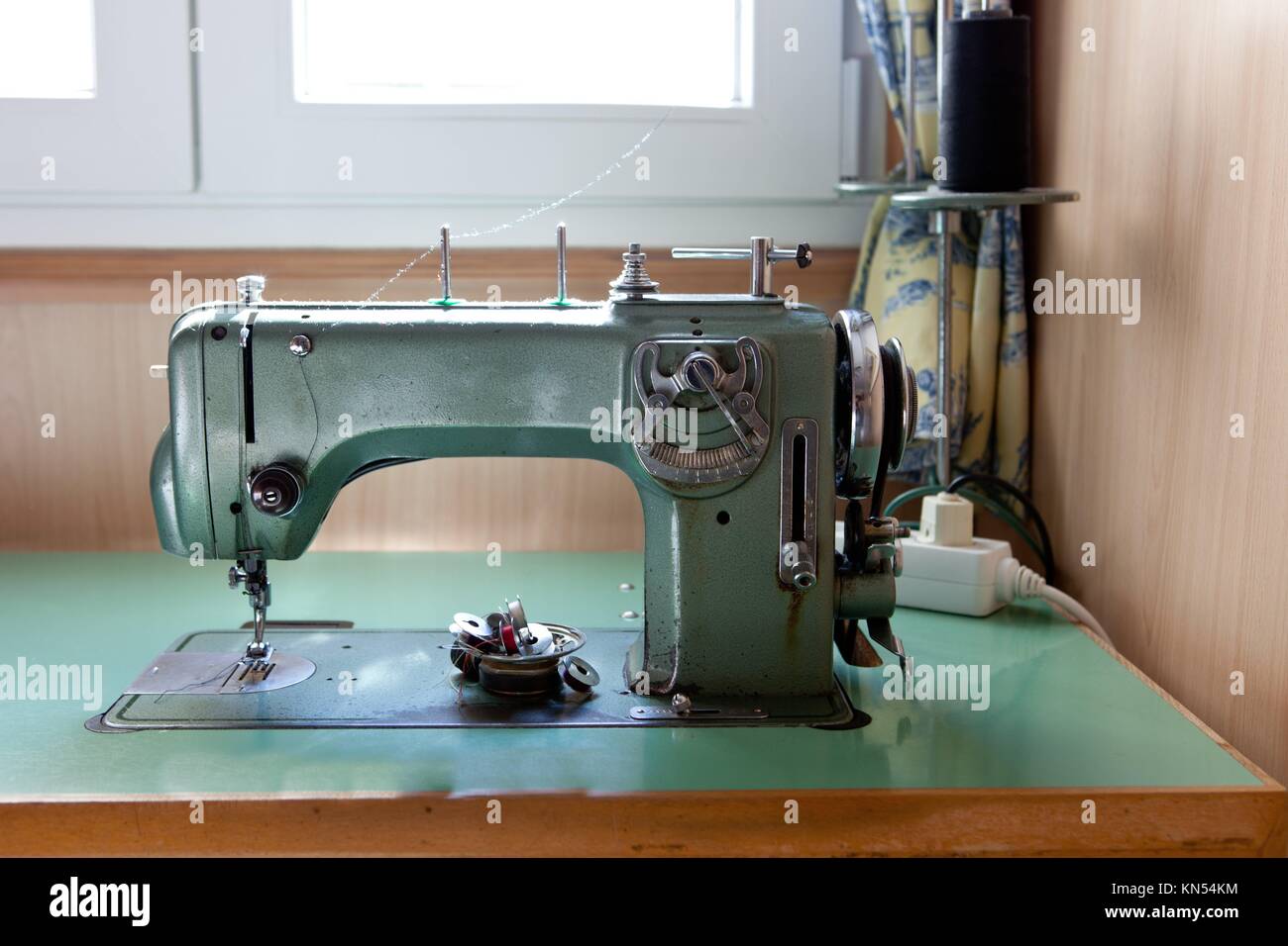 Old green electrical sewing machine at daylight. Stock Photo