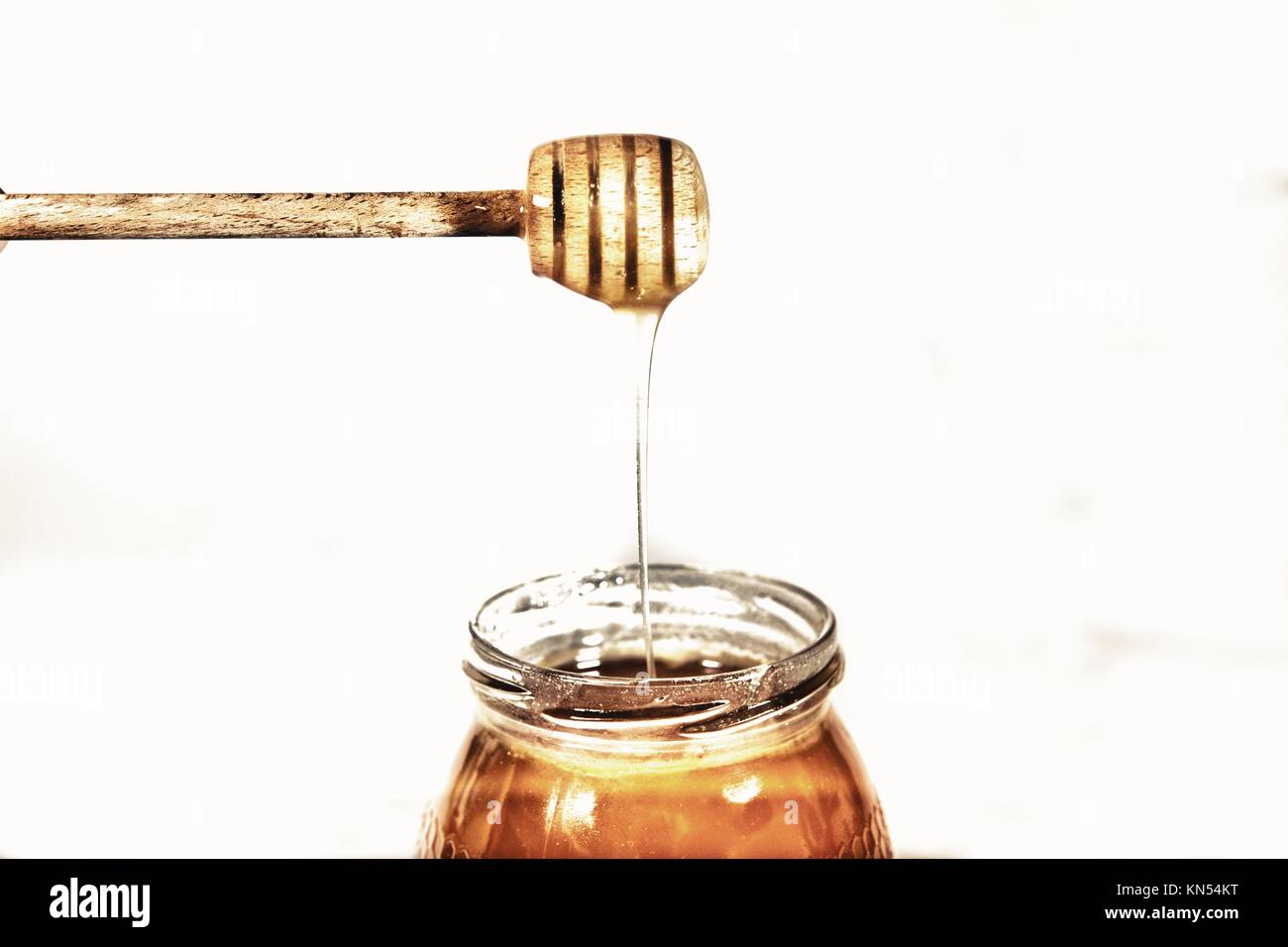 Delicious Alcarria Spanish honey and honey stick isolated over white background. Stock Photo