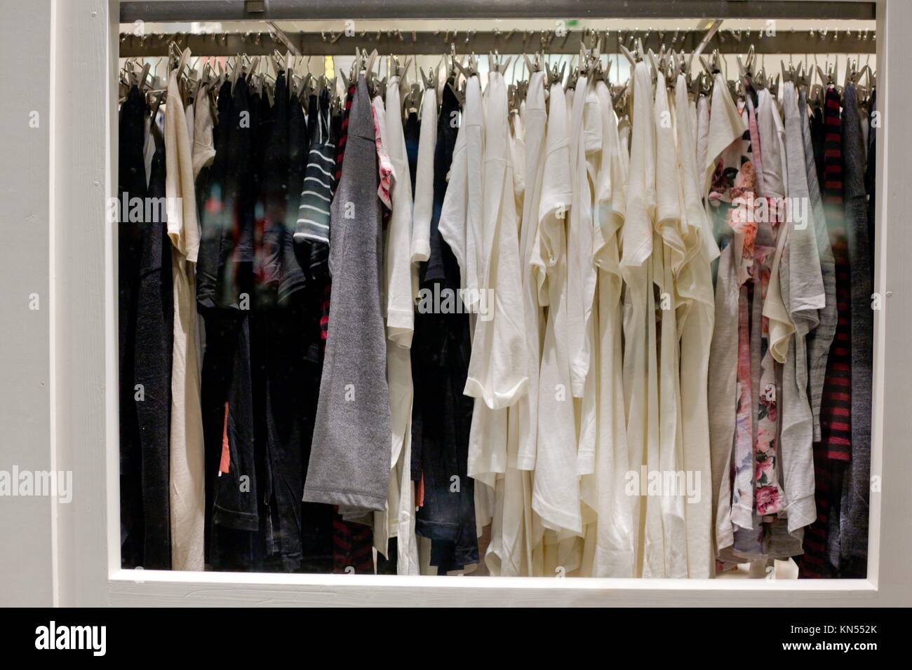 Shop window of clothing and retail store. View of clothes shop with wear hanged on stand. Stock Photo