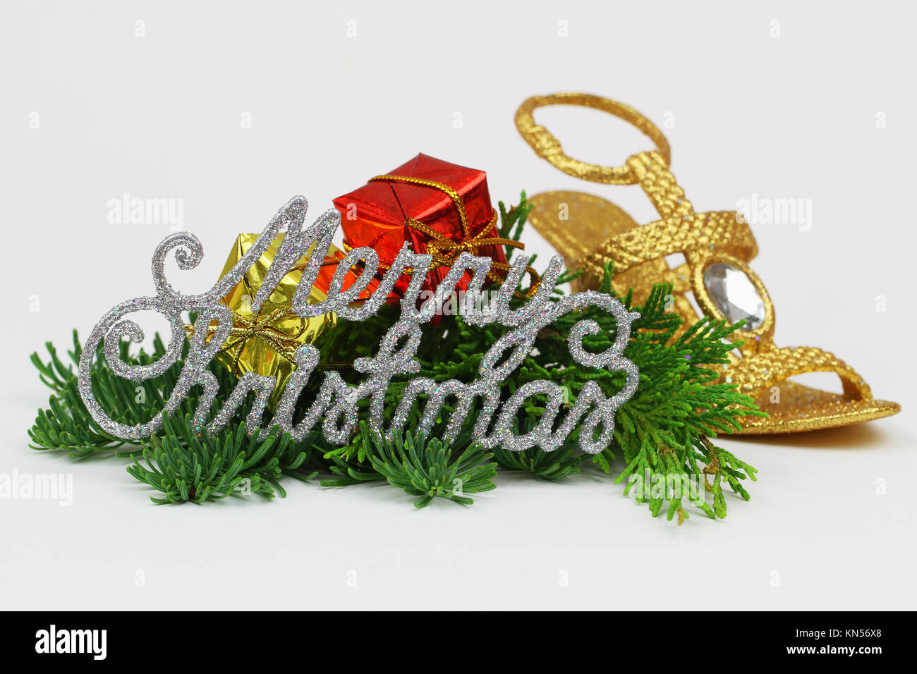 Merry Christmas written with sparkling letters and Christmas decorations on fresh pine Stock Photo