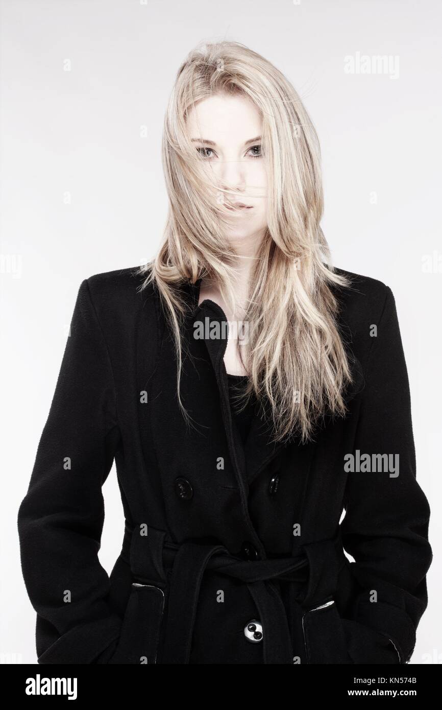 Portrait Of A Young Woman With Blond Hair And Black Coat Stock