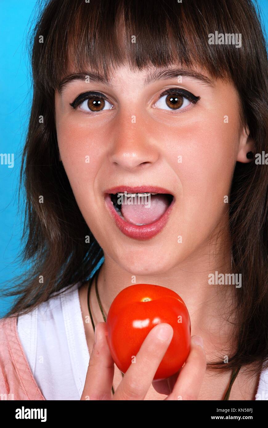 Girl eating a tomato Stock Photo Alamy