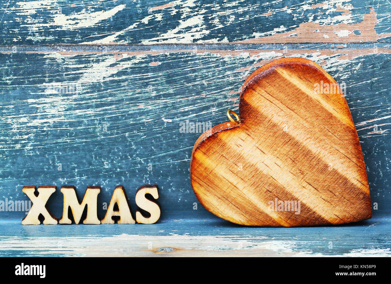 Xmas written with wooden letters and wooden heart on rustic surface Stock Photo