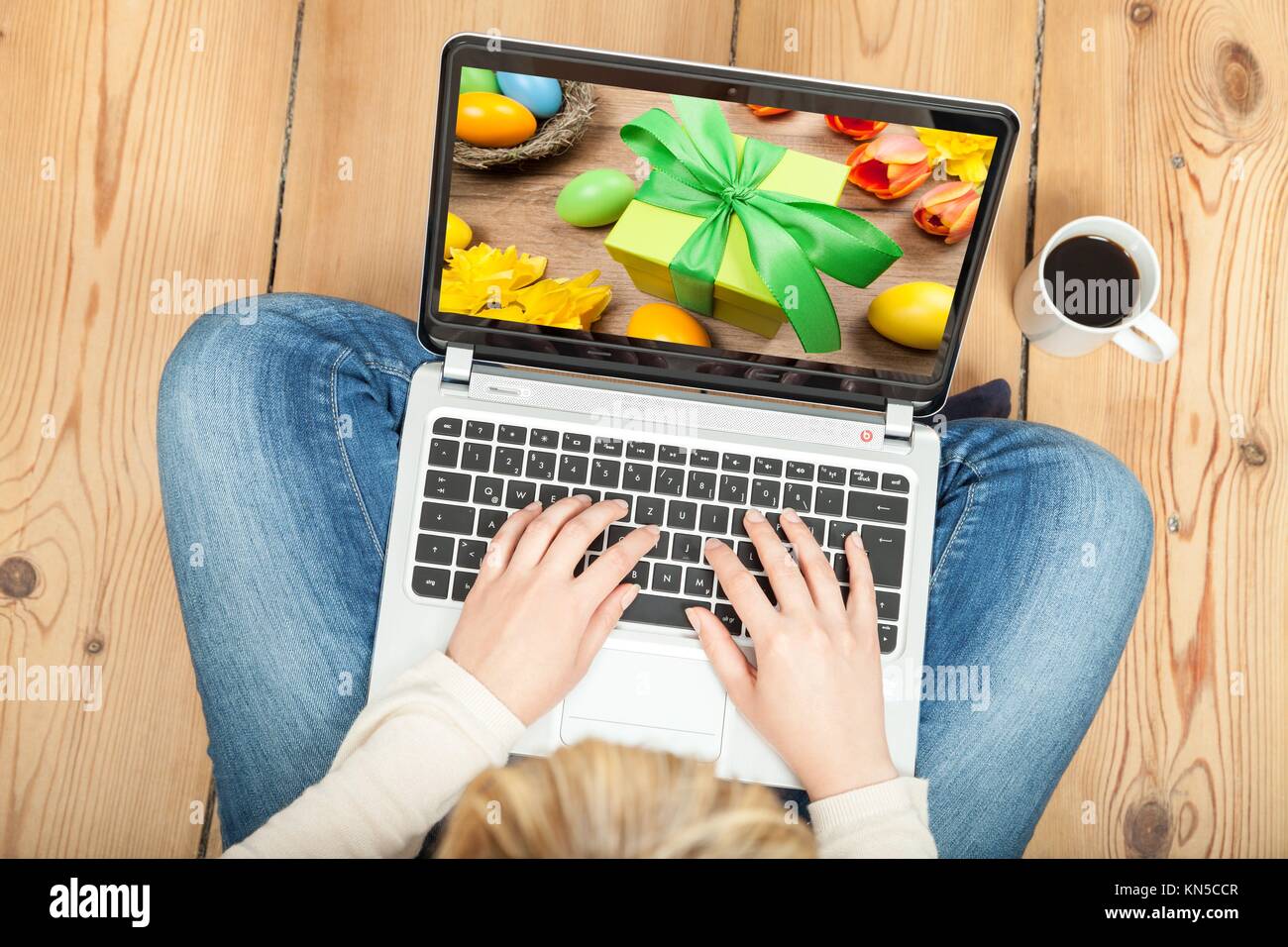 woman looking at easter still life on laptop. Stock Photo