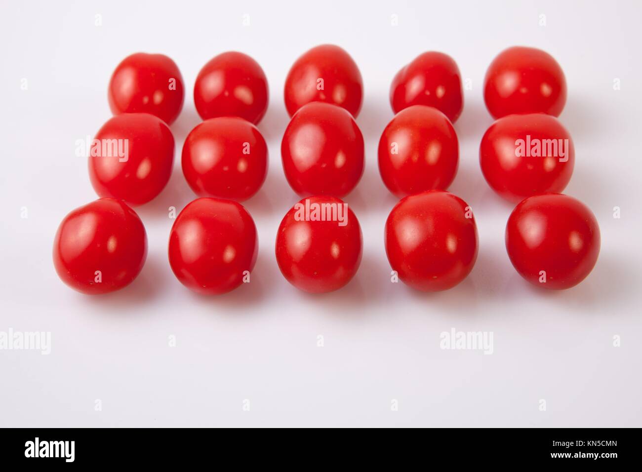 Red shiny cherry tomatoes. Isolated over white background. Stock Photo