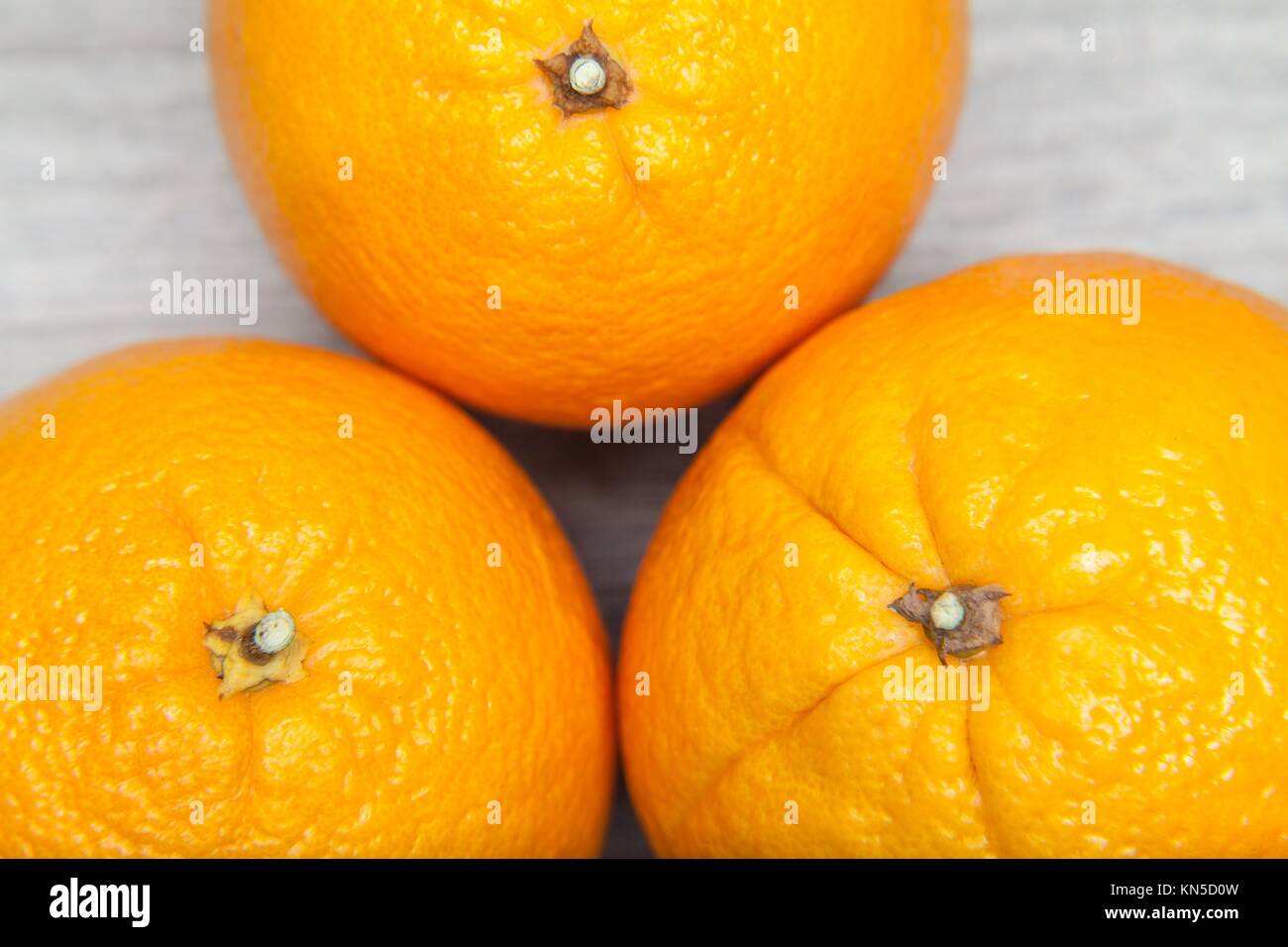 three oranges on grey table. Stock Photo