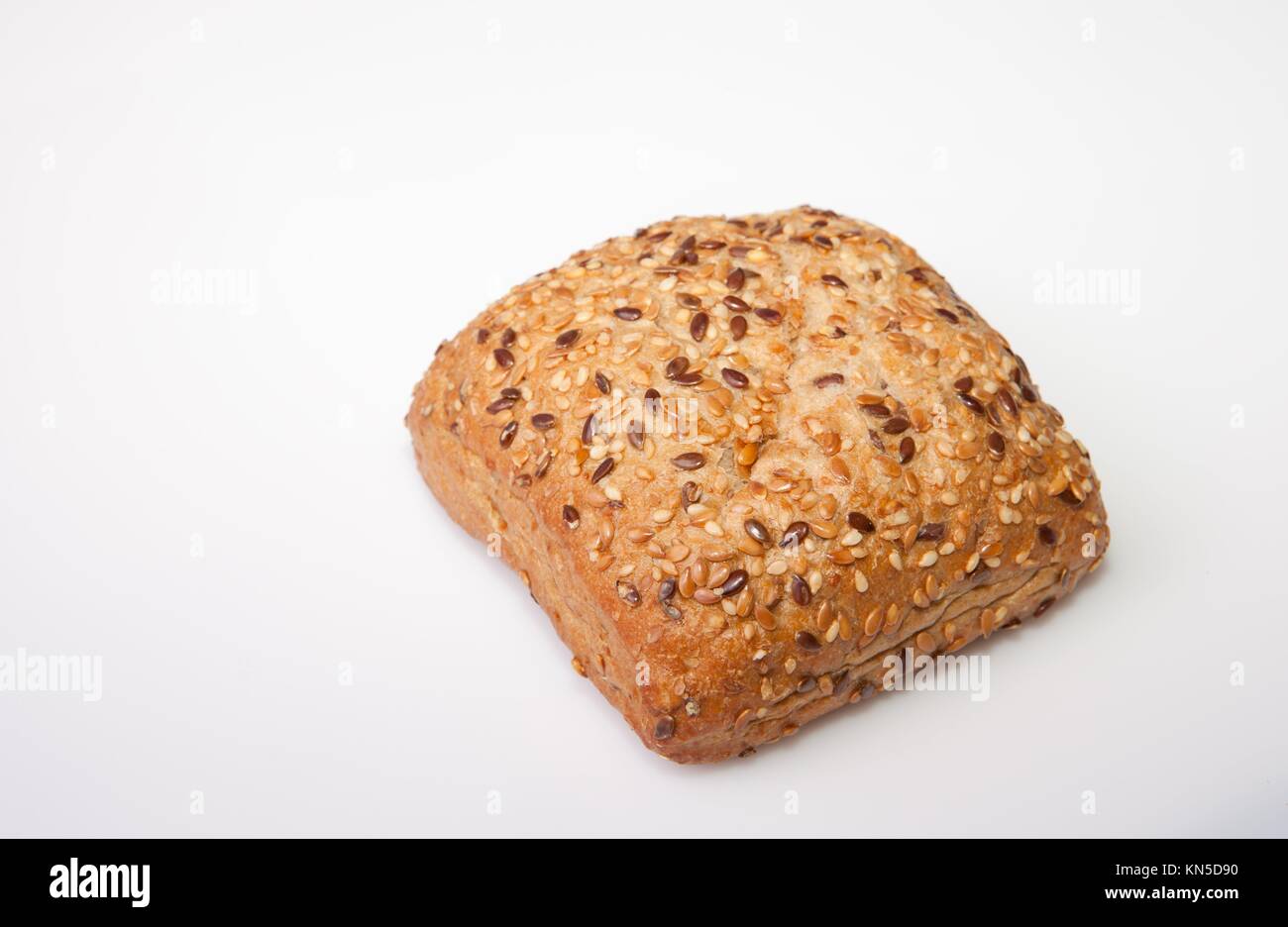 Fresh, squared wholemeal bread with sunflower seeds, sesame and others grains. Isolated over white. Stock Photo