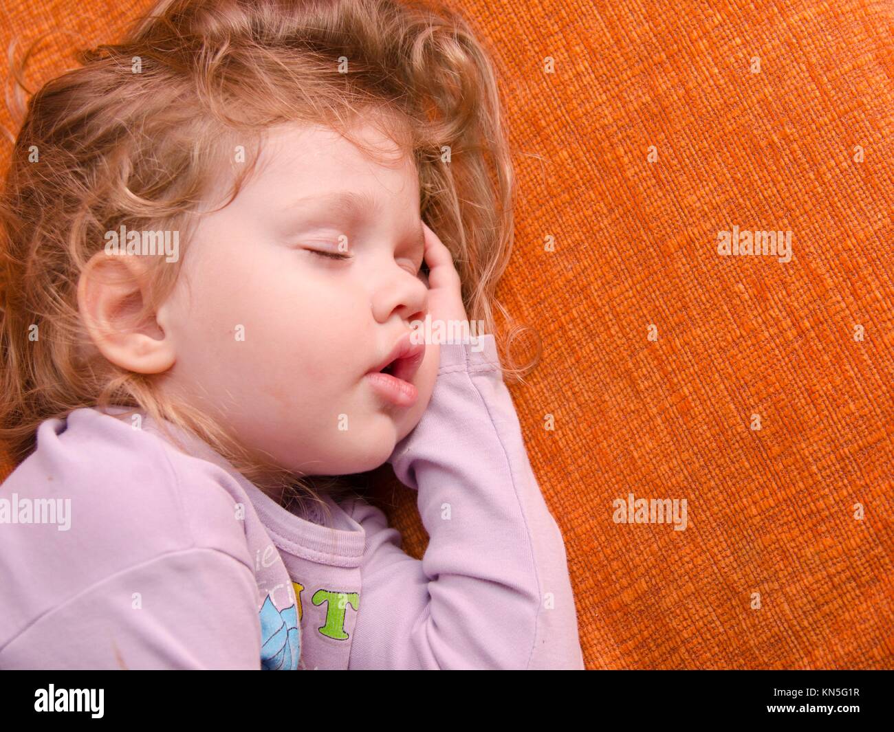 A three year old girl sleeping on the couch, placing a hand under his head Stock Photo Alamy