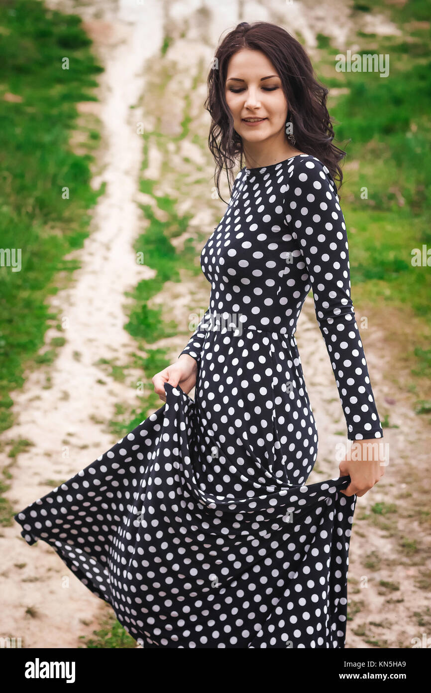 Young pretty woman with long brunette hair in vintage black dress in ...