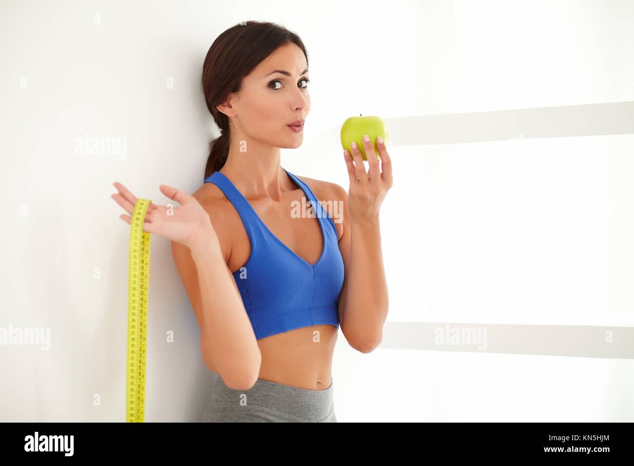 Health-conscious latin lady dieting on apple while looking at you - copyspace. Stock Photo
