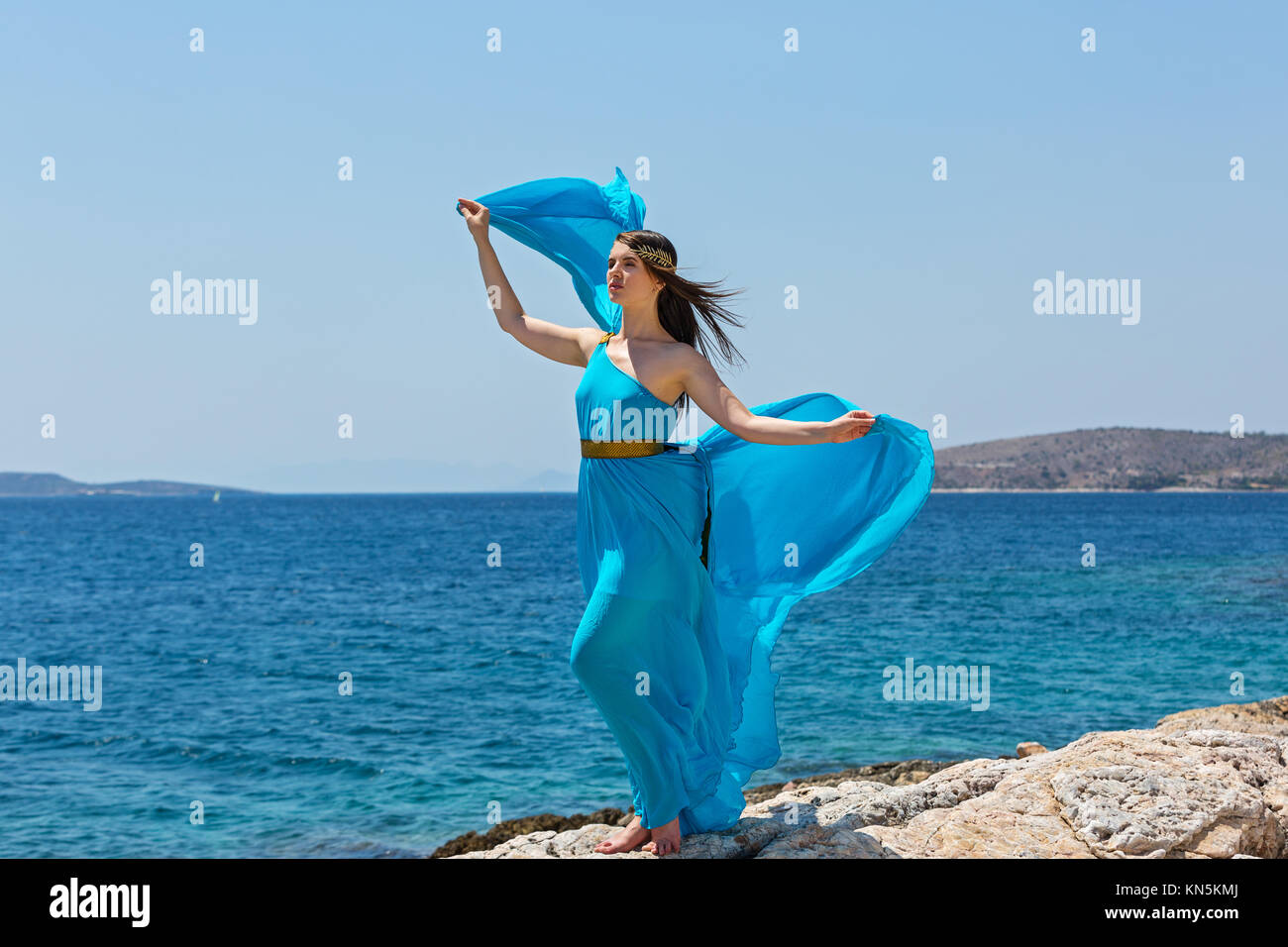 Young woman in beautiful blue dress goes in the sea, Greece Stock Photo ...