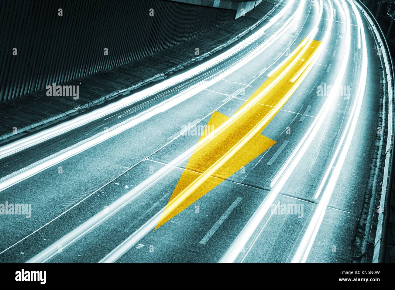 arrow on highway by night. Stock Photo