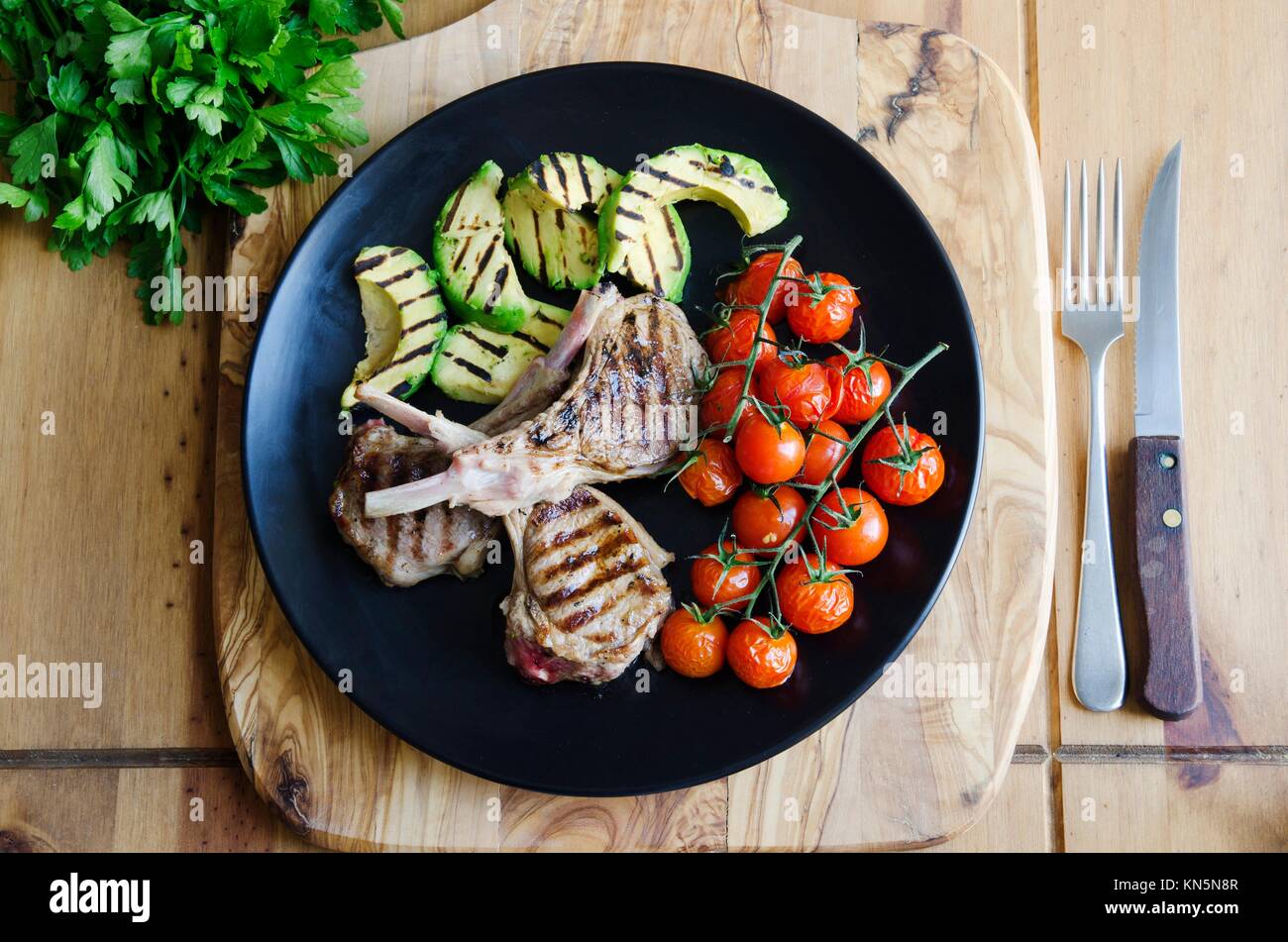 Griddled lamb cutlets with avocado and cherry tomatoes Stock Photo Alamy