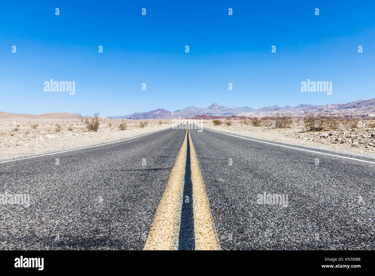 Road prospective in the middle of Death Valley desert, USA. Stock Photo
