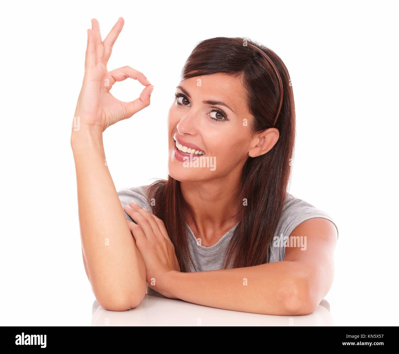 Headshot portrait of friendly girl with great job gesture smiling and looking at camera on isolated studio. Stock Photo