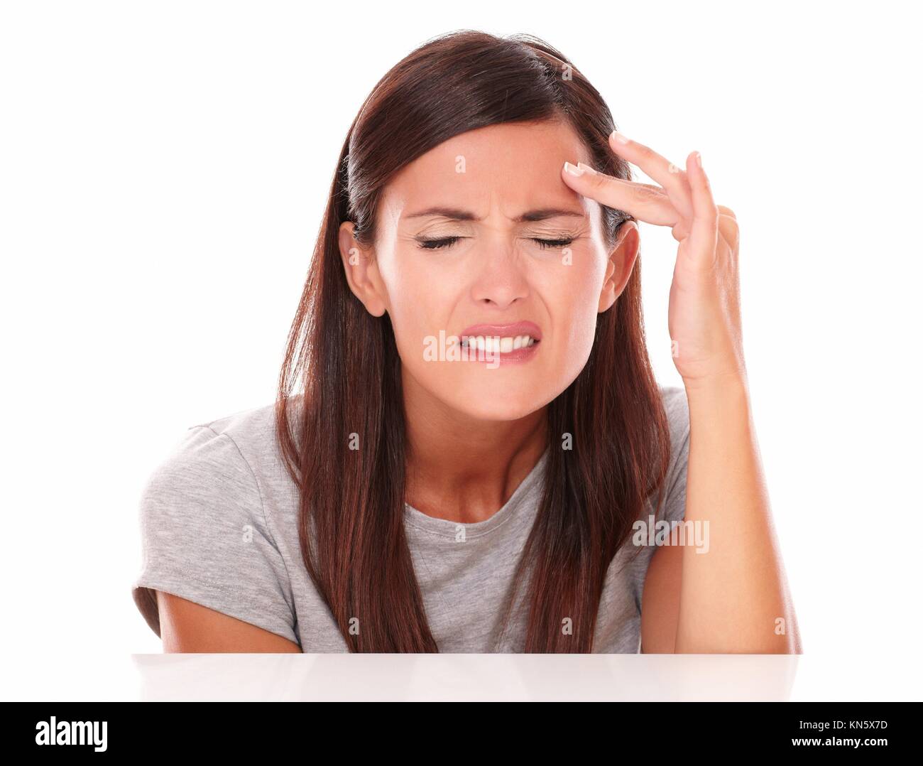 Young woman in pain with closed eyes with headache on white background