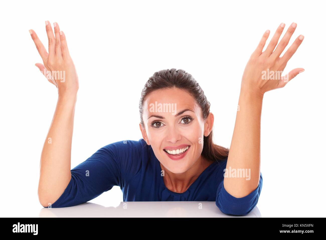Happy brunette with hands gesturing excitement while looking at you in white background. Stock Photo