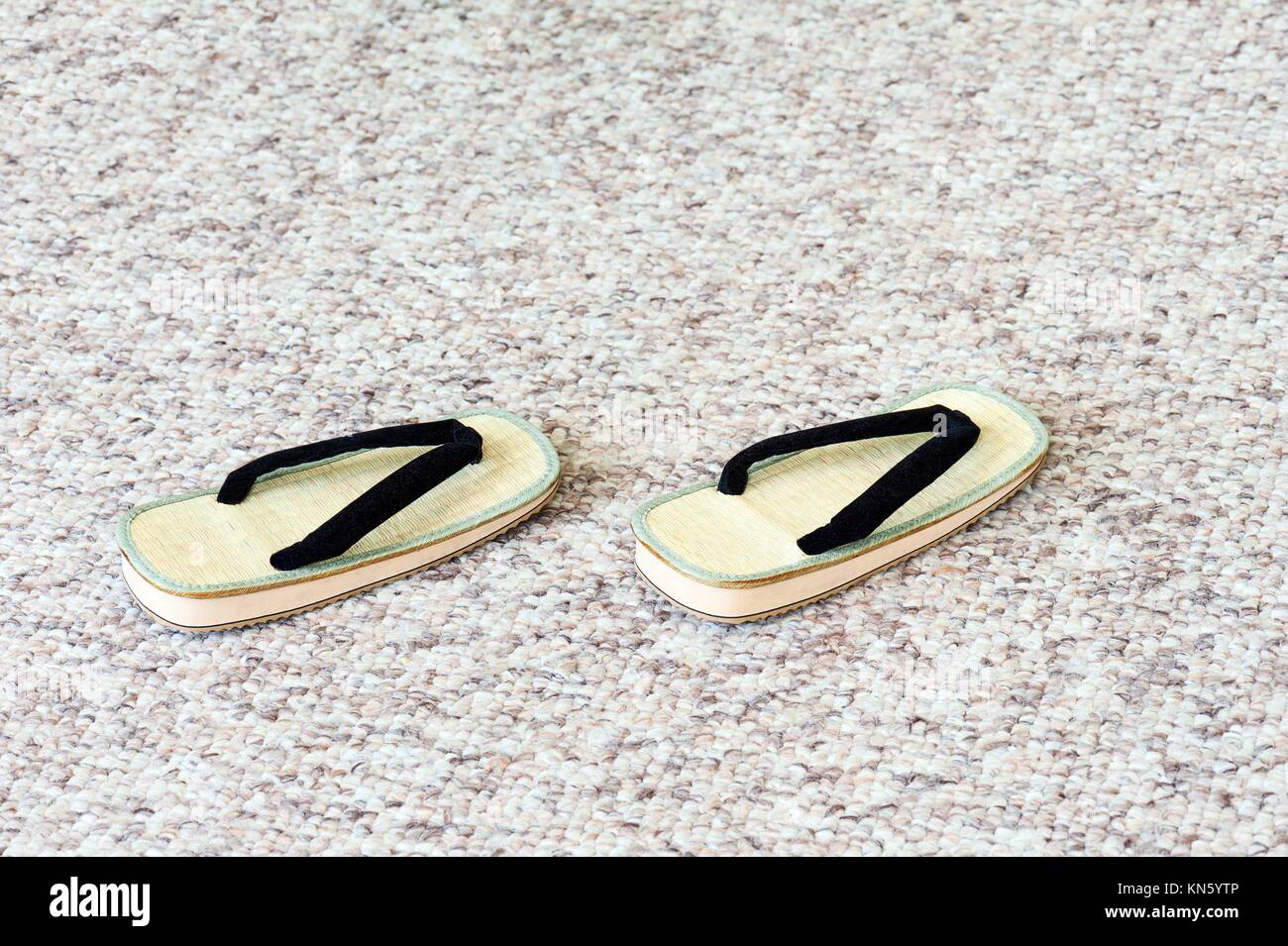 Pair of Traditional Japanese Sandals on Carpet Floor. Selective Focus. Stock Photo