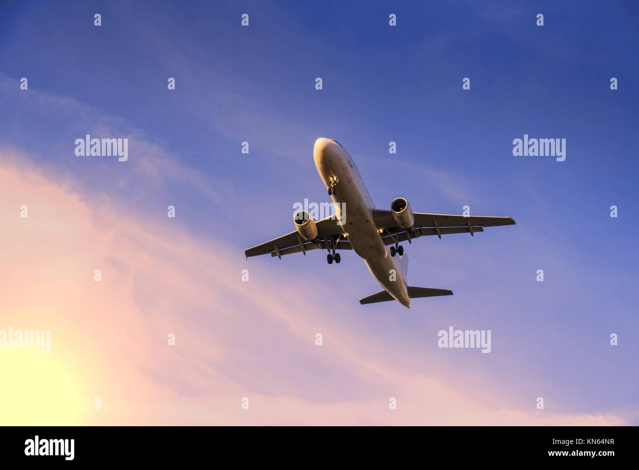 rising airplane in blue violet sky and sunlight Stock Photo - Alamy