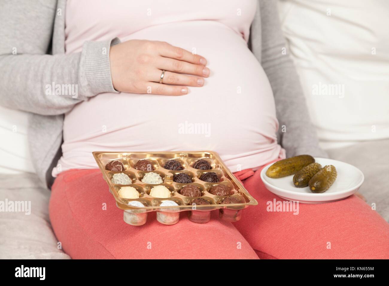 Pregnant woman with cucumber sour and candy Stock Photo Alamy