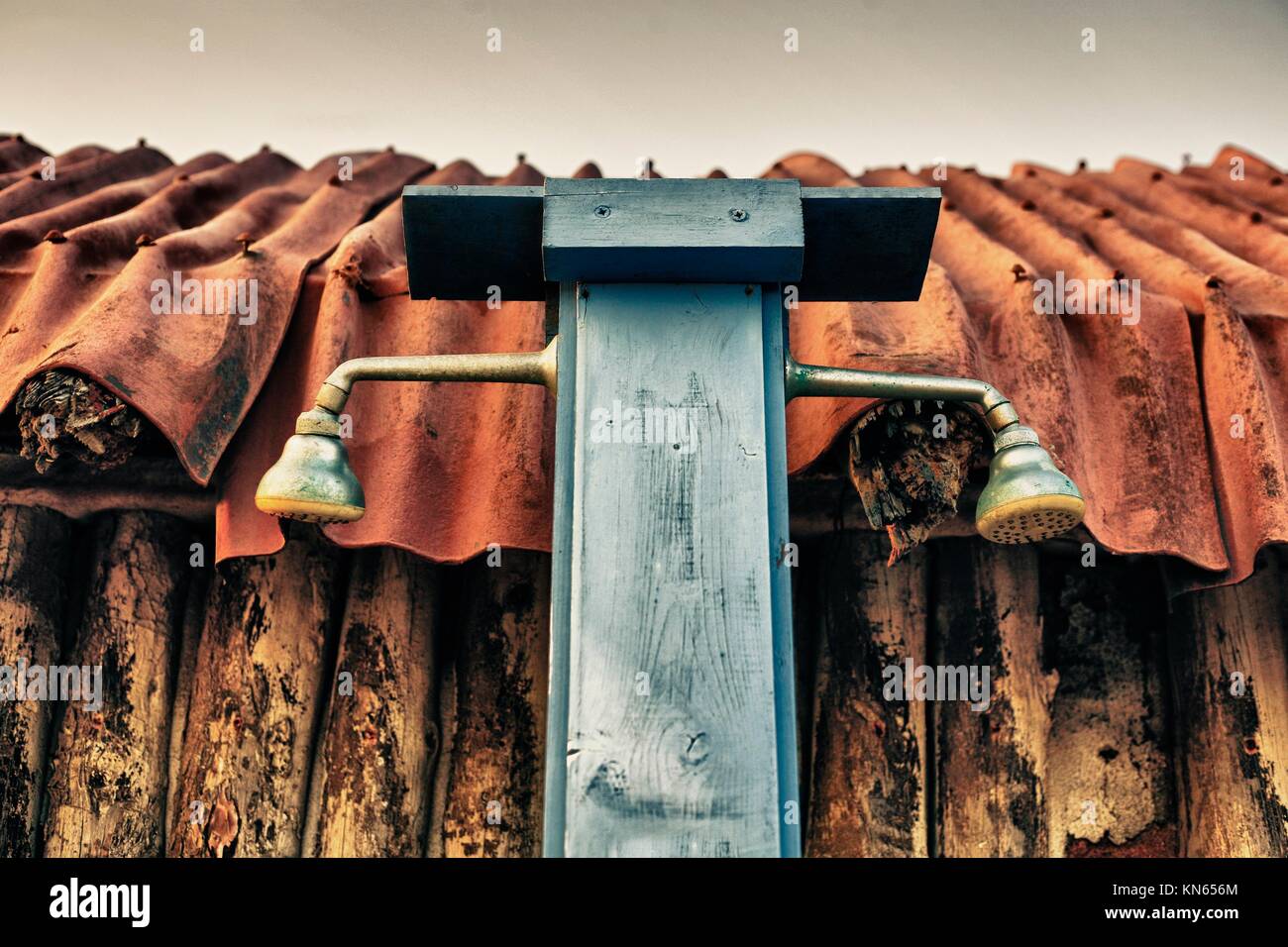 Rusty vintage beach shower attached to wooden hut. Stock Photo