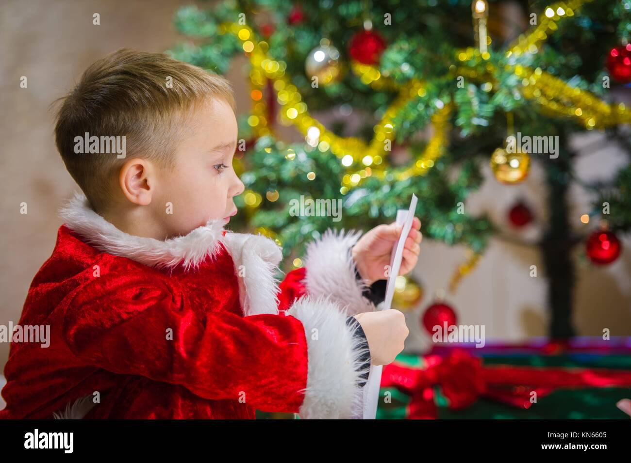 Adorable 5 year old boy check over him letter to Santa Claus, Christmas