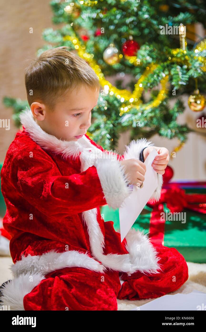 Adorable 5 year old boy closing a letter for Santa Claus, Christmas
