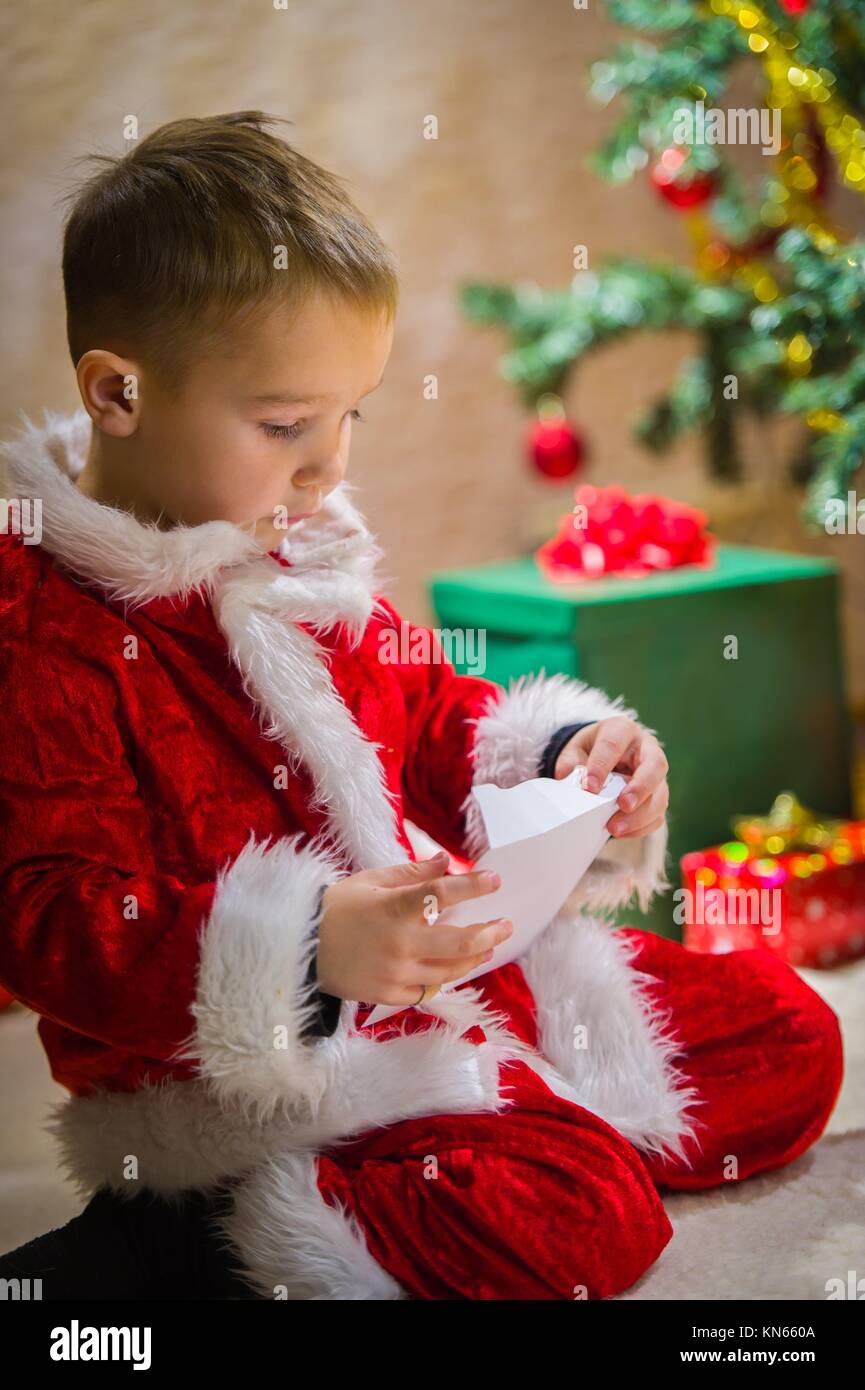 Adorable 5 year old boy closing a letter for Santa Claus, Christmas