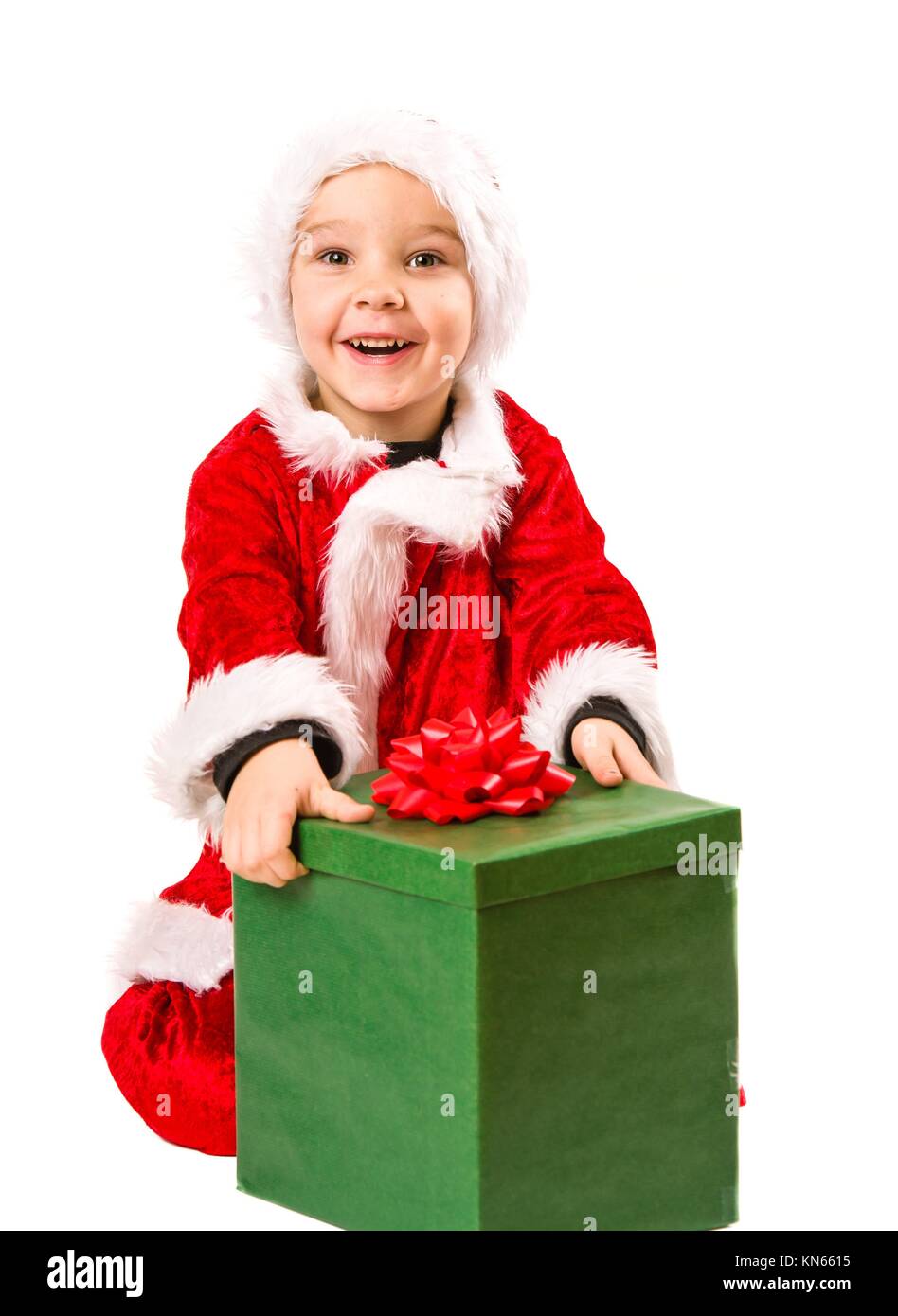 Adorable 5 year old boy wearing Santa Claus costume, he opens Christmas