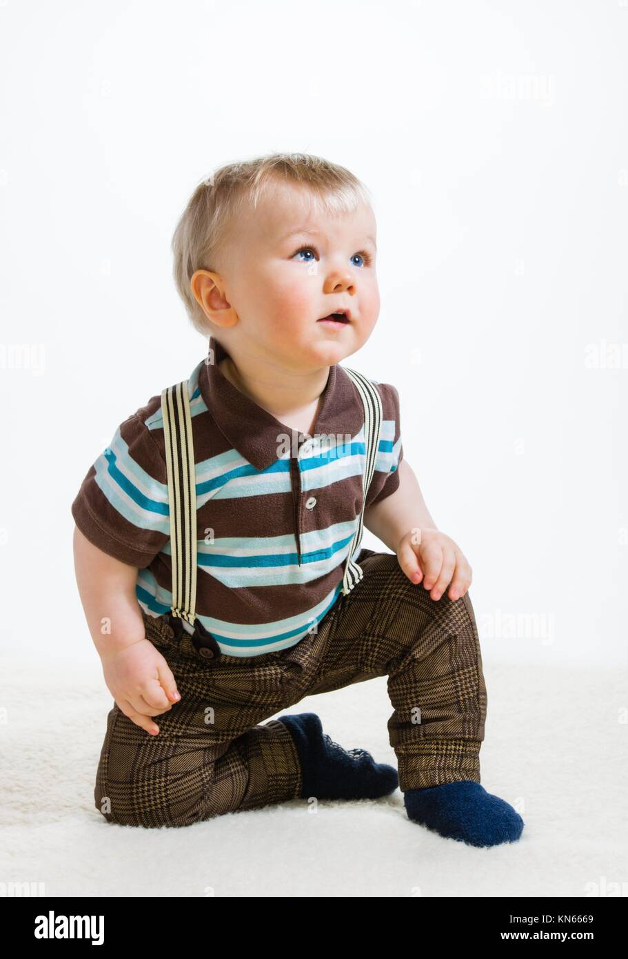 Baby boy, 16 Months old wearing striped shirt and suspenders, white background. Stock Photo