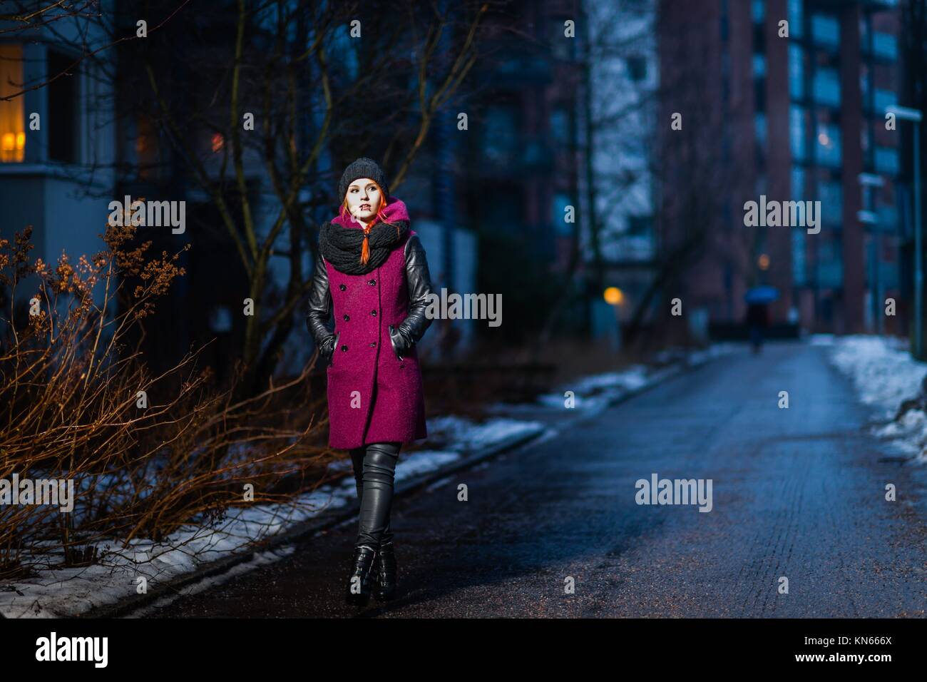Attractive woman wearing winter coat, city evening on background. Stock Photo