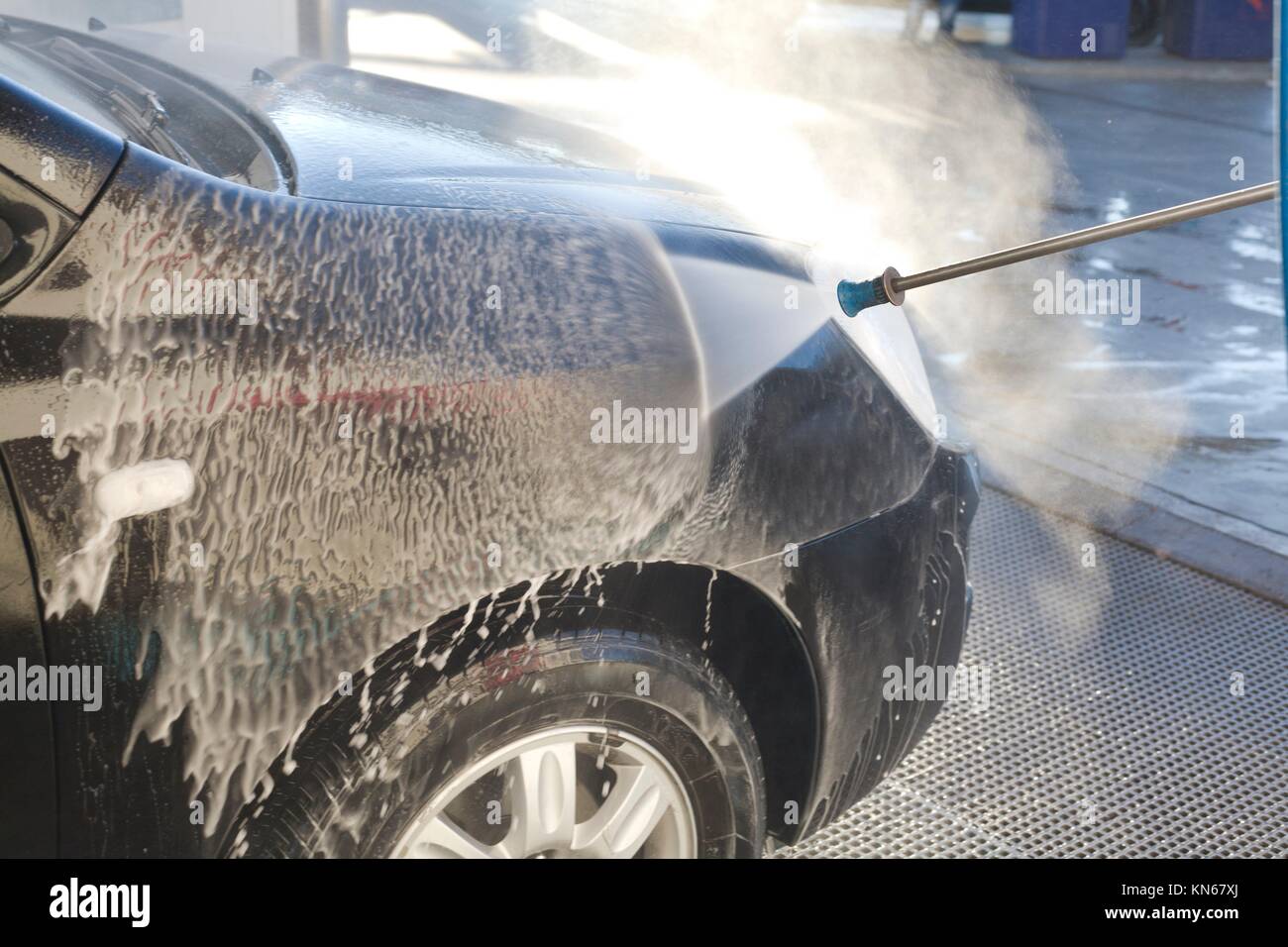 Washing with pressure gun my new black car. Stock Photo
