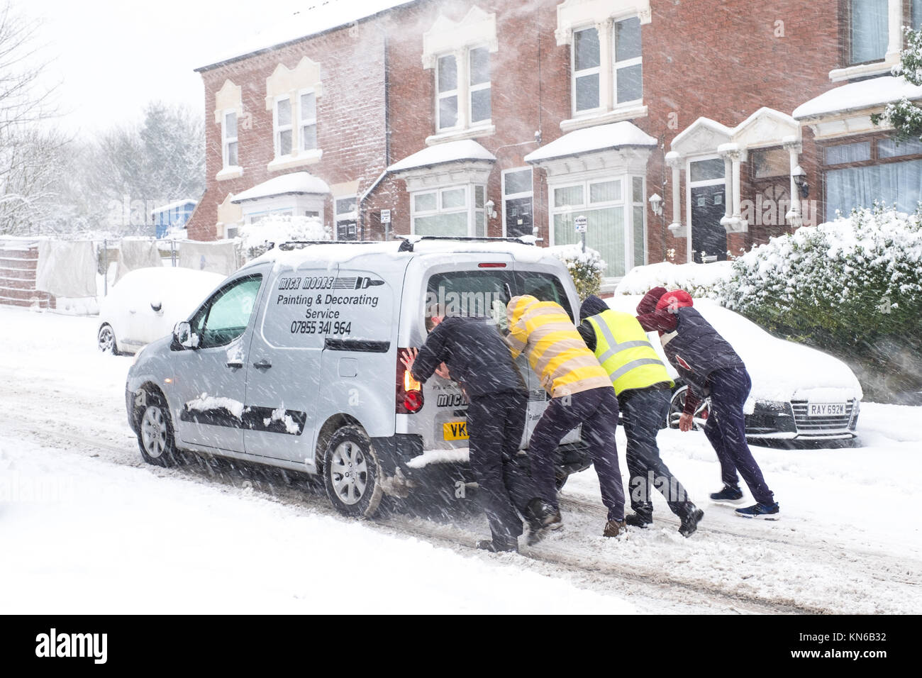 People Help Pushing Stuck Car in Heavy Snow Stock Photo