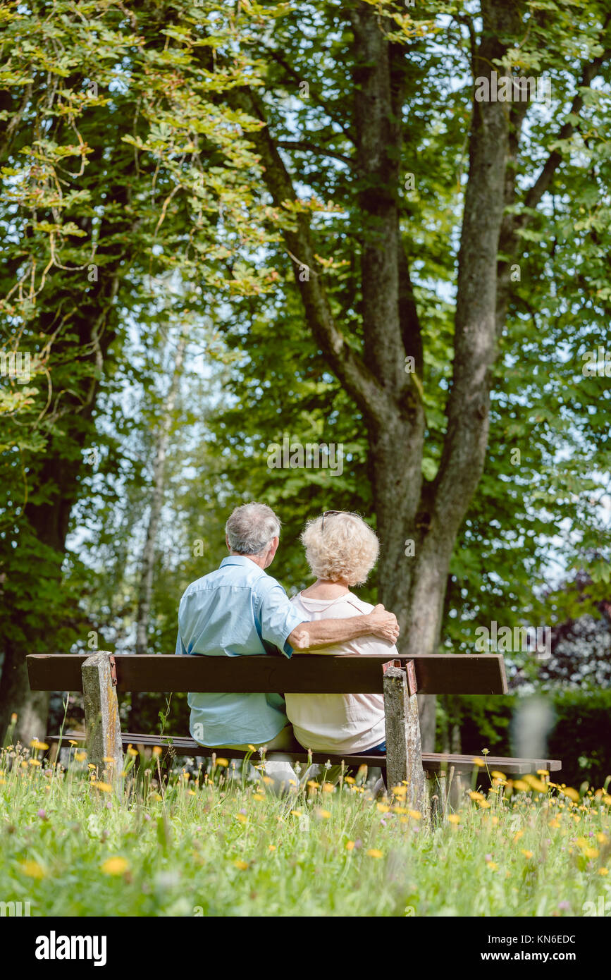 Romantic elderly couple sitting together on a bench in a tranqui Stock ...