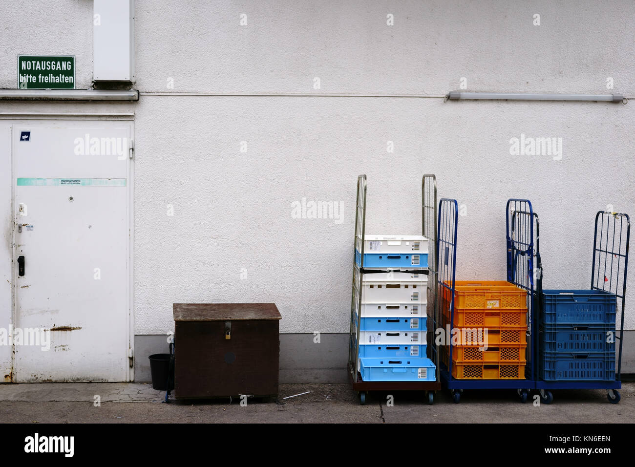 A goods receipt at the back entrance of a grocery store with boxes and pallets on rollable loading areas. Stock Photo