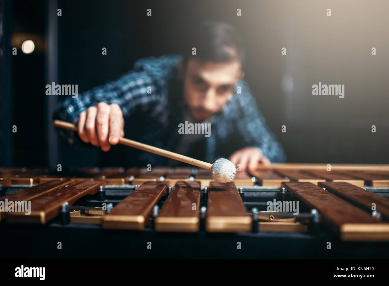 Xylophone player with sticks in hands, musician in action, wooden