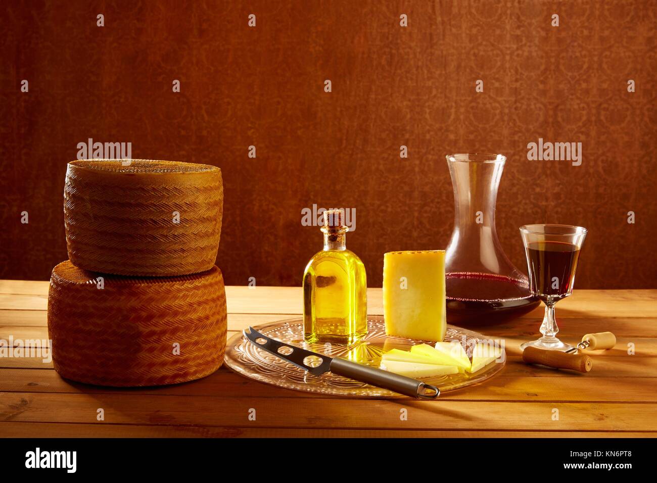 Manchego cheese from Spain with olive oil and red wine on wood Stock
