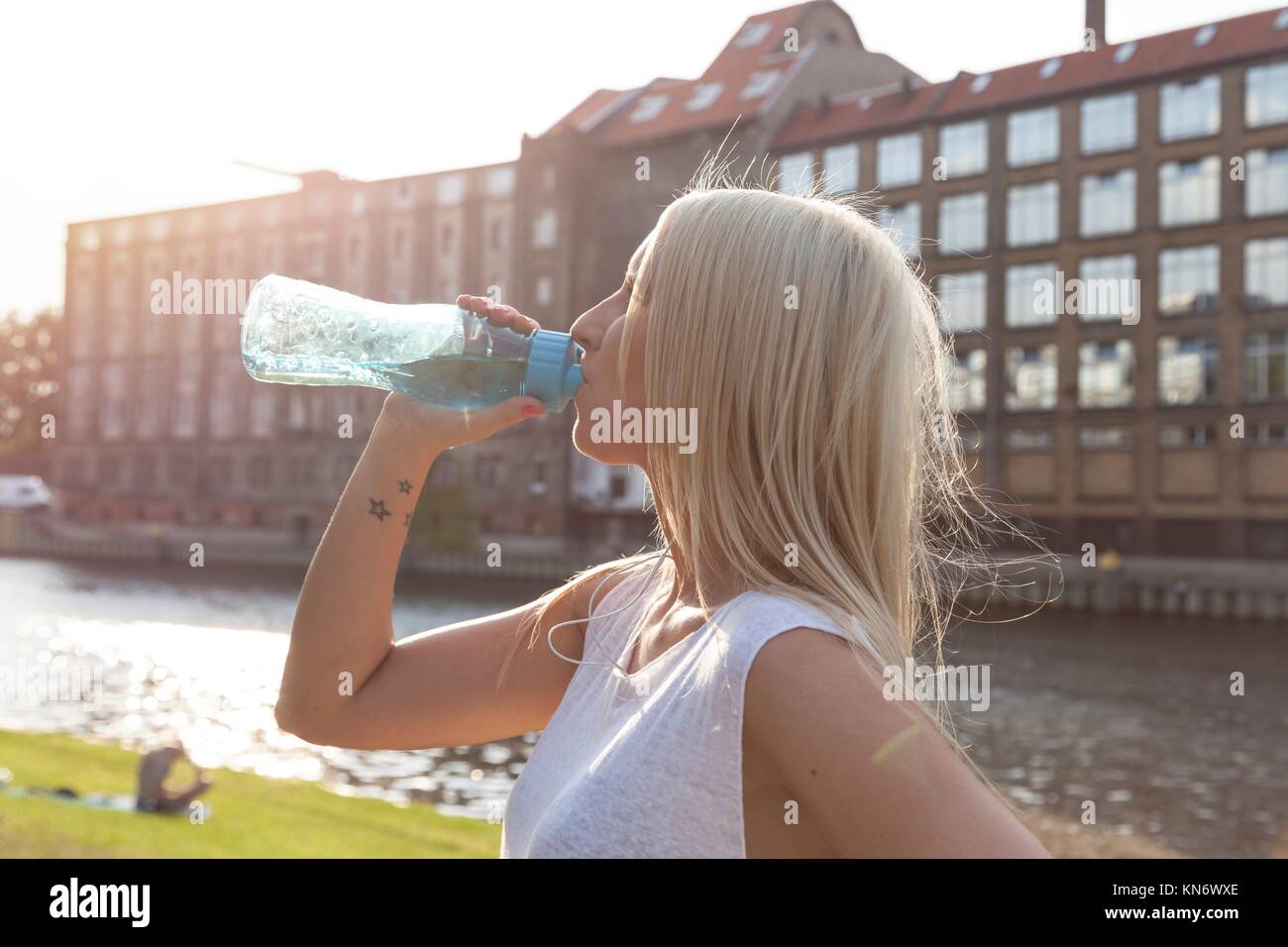 Woman drinking from a botte in summer in Berlin. Stock Photo