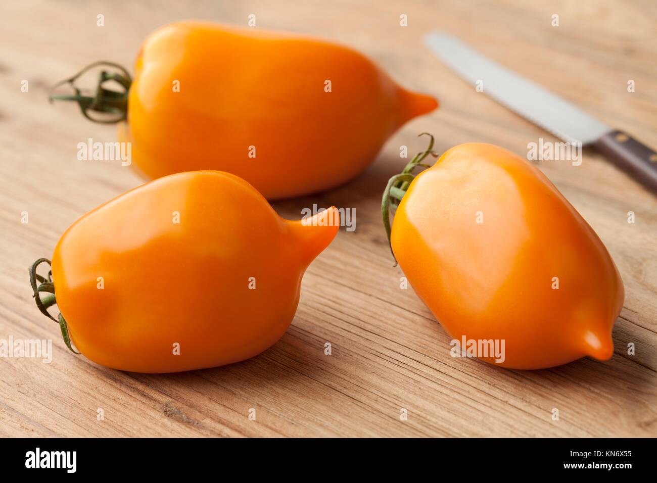 Whole and half fresh orange pepper- tomatoes. Stock Photo
