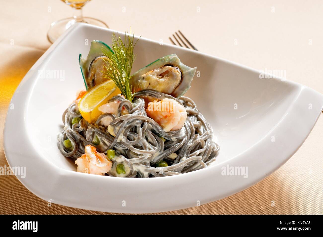 fresh seafood black squid ink coulored spaghetti pasta tipycal italian food. Stock Photo