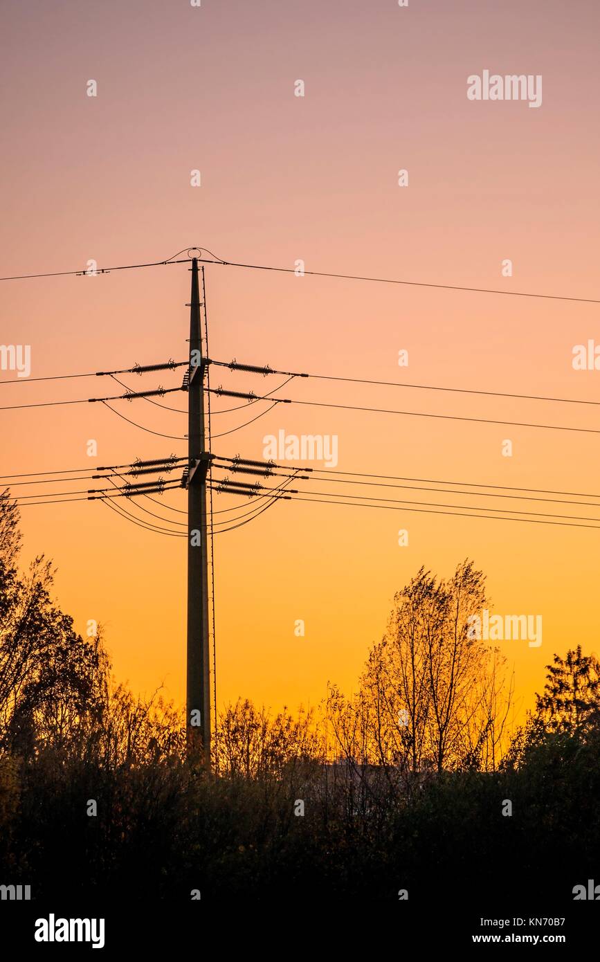 sunset with afterglow and power mast in Germany Stock Photo