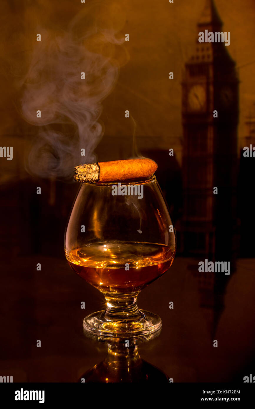 a glass of whiskey and a cigar on the table Stock Photo