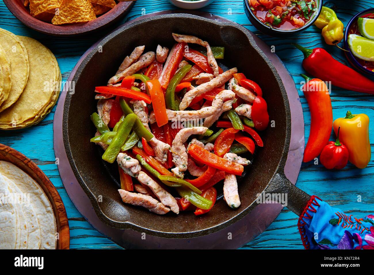 chicken fajitas in a pan with sauces chili and sides Mexican food Stock
